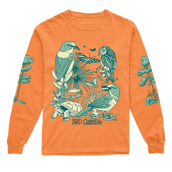 Photo of an orange long sleeve tee featuring a blue-green and ivory graphic with two Florida Scrub Jay, a Grasshopper Sparrow and Gopher Tortoise surrounded by several plants and insects. Each tee has a slash pine printed along its length. 
